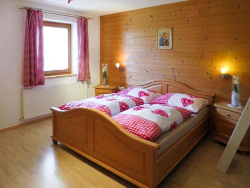 sypialnia z łóżkiem z białymi i czerwonymi poduszkami w obiekcie Apartment Marianne - FGZ163 by Interhome w mieście Hart im Zillertal