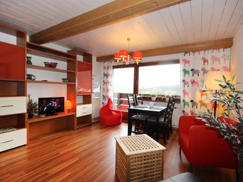 ein Wohnzimmer mit einem roten Sofa und einem Tisch in der Unterkunft Apartment Karina by Interhome in Seefeld in Tirol