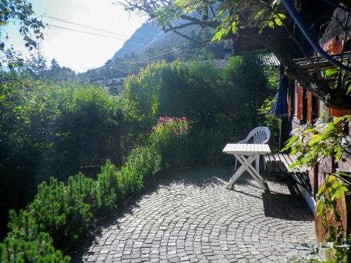 a white bench sitting in the middle of a garden at Chalet Hüttl - GSN100 by Interhome in Trins