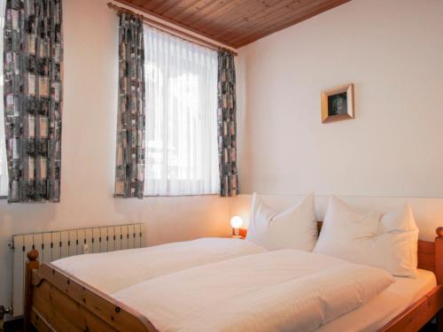 Schlafzimmer mit einem weißen Bett und einem Fenster in der Unterkunft Apartment Edelweiss-1 by Interhome in Werfenweng