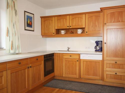a kitchen with wooden cabinets and a sink at Holiday Home Schönhart by Interhome in Lippbauer