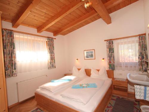 a bedroom with a large white bed and a sink at Appartement Rifflerblick in Pettneu am Arlberg