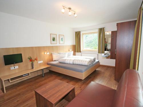 1 dormitorio con 1 cama y TV en Apartment Urgbach Apart-1 by Interhome, en Landeck