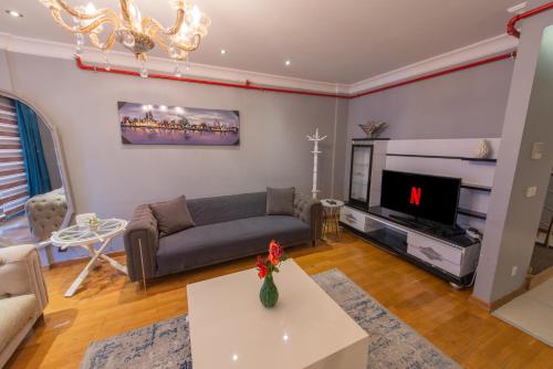 a living room with a couch and a tv at CTS Elysium Residence Taksim in Istanbul
