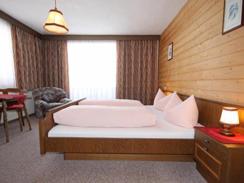 ein Hotelzimmer mit 2 Betten und einem Stuhl in der Unterkunft Apartment Obernberg by Interhome in Obernberg am Brenner