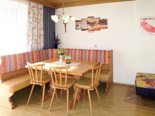 uma sala de jantar com uma mesa de madeira e cadeiras em Apartment Daheim – Bergliebe - PZT381 by Interhome em Plangeross