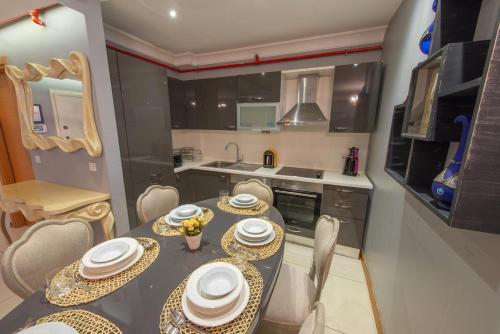 a kitchen with a table and chairs with plates and bowls at CTS Elysium Residence Taksim in Istanbul