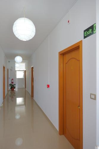 an empty hallway with a exit sign and a door at Aleksander ApartHotel in Ksamil