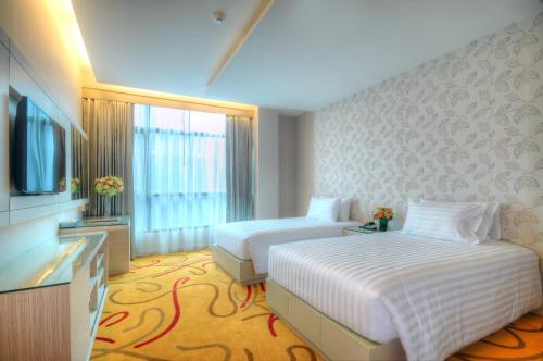 a hotel room with two beds and a flat screen tv at One One Bangkok in Bangkok