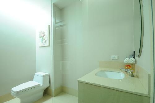 a bathroom with a toilet and a sink and a shower at One One Bangkok in Bangkok