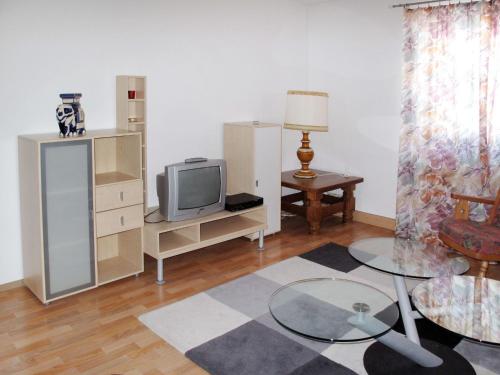 a living room with a tv and a table at Apartment Altes Zollhaus-2 by Interhome in Nauders