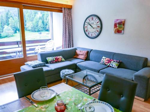 salon z kanapą i zegarem na ścianie w obiekcie Apartment Rosablanche D31 by Interhome w mieście Siviez