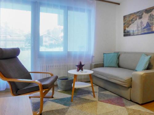 un soggiorno con divano, sedia e tavolo di Apartment Imperial-1 by Interhome a Zermatt