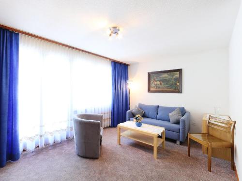 sala de estar con sofá azul y mesa en Apartment Imperial-4 by Interhome, en Zermatt
