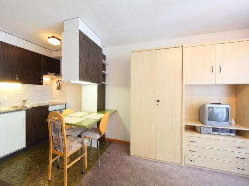 a small kitchen with a table and a microwave at Apartment Imperial-4 by Interhome in Zermatt