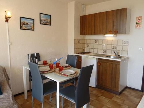 a kitchen with a table and chairs in a kitchen at Apartment Gruissan Port-2 by Interhome in Gruissan