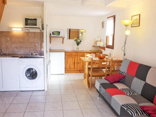 Una sala de estar con un sofá y una cocina. en Holiday Home Les Maisons du Rivage Bleu by Interhome, en Narbonne-Plage