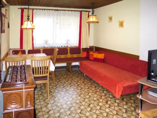 - un salon avec un canapé rouge et une table dans l'établissement Apartment Elisabeth - ZAZ778 by Interhome, à Aschau