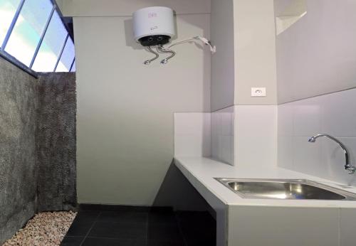 een keuken met een wastafel en een lampje aan de muur bij Amerta Home Stay Bali in Denpasar