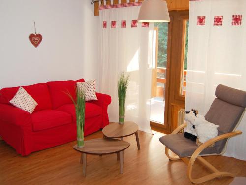 un soggiorno con divano rosso e sedia di Apartment Quille du Diable 33 by Interhome a Nendaz