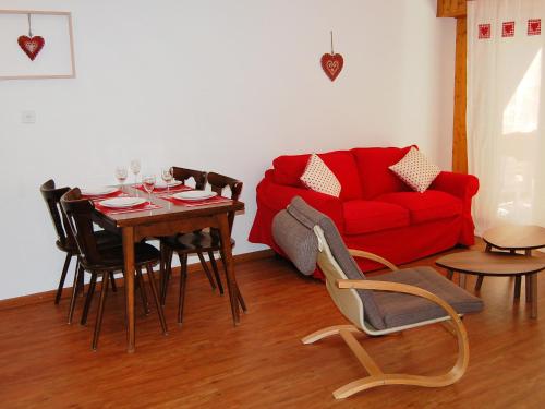 un soggiorno con tavolo e divano rosso di Apartment Quille du Diable 33 by Interhome a Nendaz