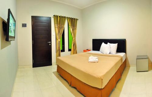 Un dormitorio con una cama y una puerta. en Amerta Home Stay Bali, en Denpasar