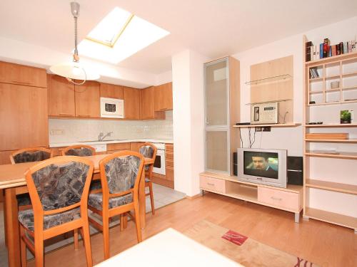eine Küche und ein Esszimmer mit einem Tisch und einem TV in der Unterkunft Apartment Krismer by Interhome in Pians