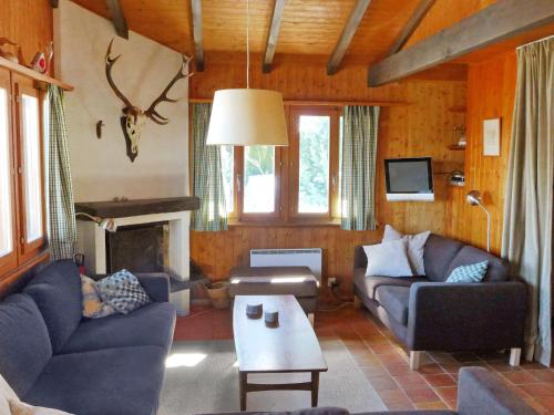 een woonkamer met twee banken en een open haard bij Chalet Sven Heul by Interhome in Nendaz