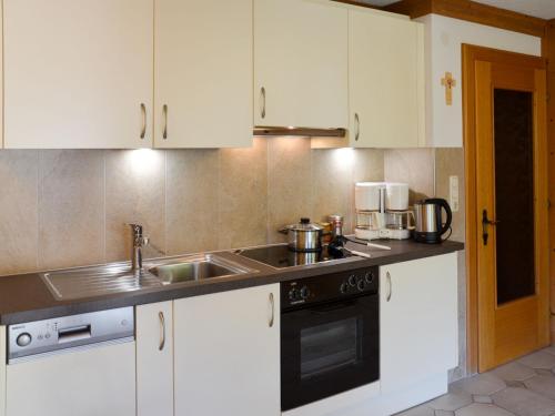 kuchnia z białymi szafkami i zlewem w obiekcie Apartment Schranz - KPL520 by Interhome w mieście Kappl