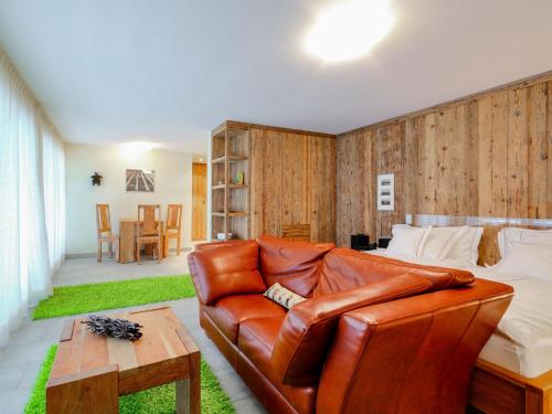 ein Wohnzimmer mit einem Ledersofa und einem Tisch in der Unterkunft Apartment Rütschi-3 by Interhome in Zermatt