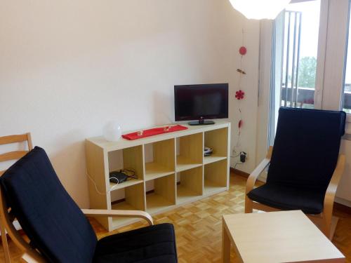 sala de estar con TV y 2 sillas en Apartment Valaisia 34A by Interhome, en Nendaz