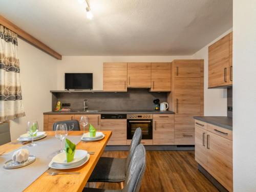 kuchnia z drewnianym stołem z krzesłami i jadalnią w obiekcie Apartment Christoph-2 by Interhome w mieście Kappl