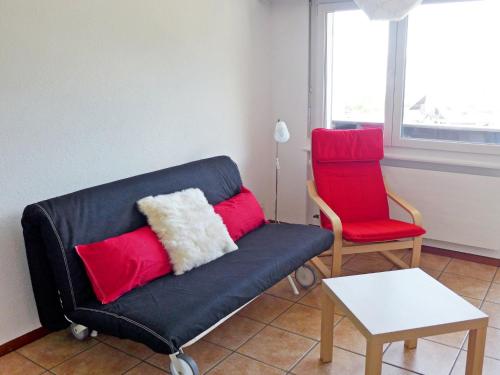 sala de estar con sofá y silla roja en Apartment Valaisia 35A by Interhome, en Nendaz
