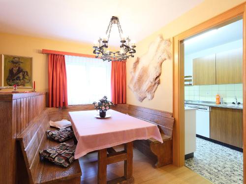 une cuisine avec une table et un tissu de table rose dans l'établissement Apartment St- Martin by Interhome, à Zermatt