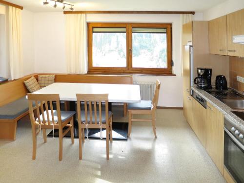 a kitchen with a table and chairs in a kitchen at Holiday Home Julia by Interhome in Kappl
