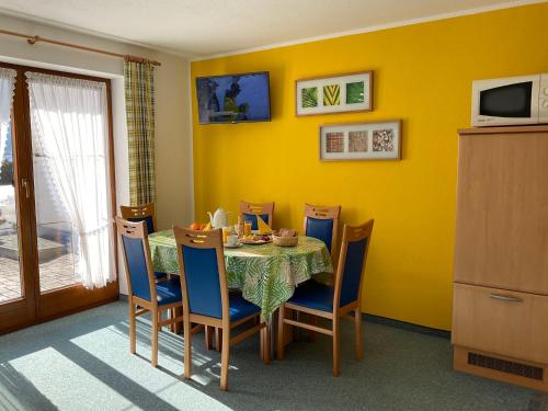 een eetkamer met een tafel en stoelen en een gele muur bij Apartment Christina - IST400 by Interhome in Tarrenz