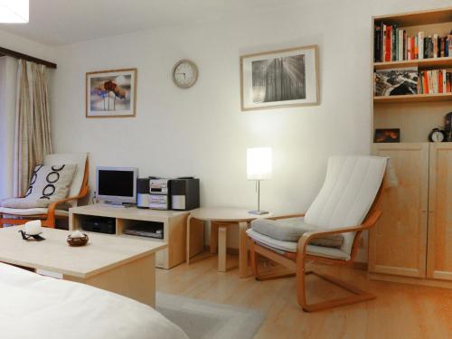 ein Wohnzimmer mit einem Bett und einem Schreibtisch mit einem Computer in der Unterkunft Apartment Silence-1 by Interhome in Zermatt
