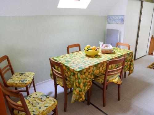 stół z krzesłami i miską owoców na nim w obiekcie Apartment Les Marmottes by Interhome w mieście Barèges