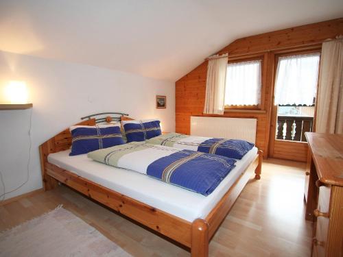 Schlafzimmer mit einem Bett mit blauen und weißen Kissen in der Unterkunft Apartment Sonnenheim-2 by Interhome in Mayrhofen