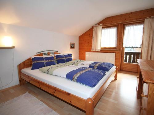 sypialnia z łóżkiem z niebiesko-białymi poduszkami w obiekcie Apartment Sonnenheim-2 by Interhome w Mayrhofen