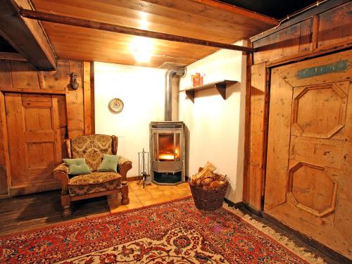 a living room with a chair and a fireplace at Holiday Home Hochzillertalblick by Interhome in Gattererberg