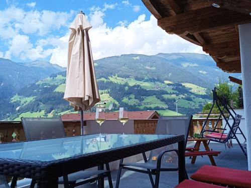 eine Terrasse mit einem Tisch und einem Sonnenschirm in der Unterkunft Apartment Chalet Modern Life - MHO769 by Interhome in Ramsau im Zillertal