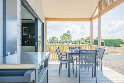 une cuisine et une salle à manger avec une table et des chaises dans l'établissement Chalet pour 6, résidence de vacances avec piscine, à Bretignolles-sur-Mer