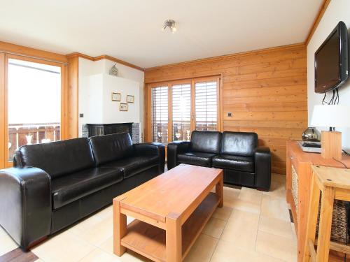 a living room with black leather furniture and a tv at Apartment Les Terrasses du Paradis 5a by Interhome in Nendaz
