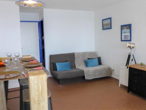 een woonkamer met een bank en een tafel bij Apartment Les Occitanes by Interhome in Gruissan