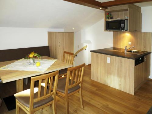 uma cozinha com uma mesa e cadeiras e um lavatório em Apartment Alpenblick - SOE750 by Interhome em Sölden