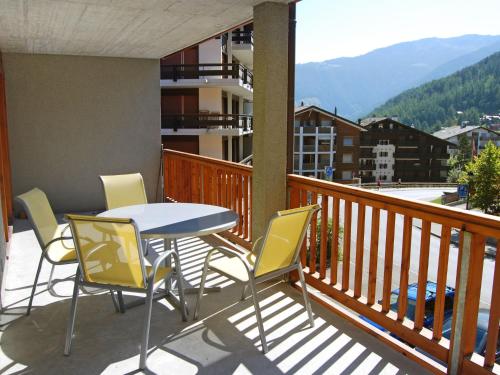a porch with a table and chairs on a balcony at Apartment Les Chouettes 22 by Interhome in Nendaz