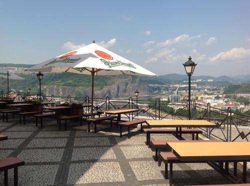 a group of picnic tables with an umbrella at Hotel Větruše in Ústí nad Labem