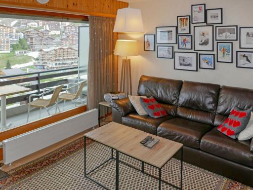 ein Wohnzimmer mit einem Ledersofa und einem Tisch in der Unterkunft Apartment Rossignol C4 by Interhome in Nendaz