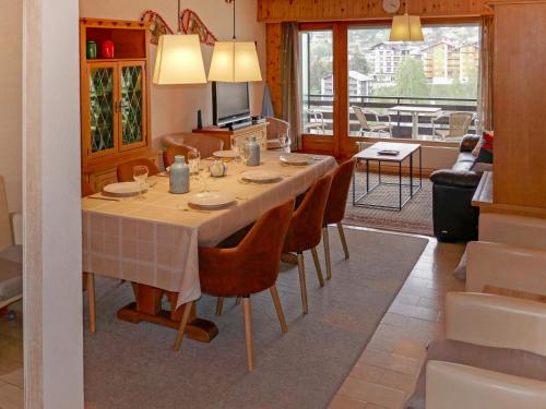 einen Esstisch und Stühle im Wohnzimmer in der Unterkunft Apartment Rossignol C4 by Interhome in Nendaz
